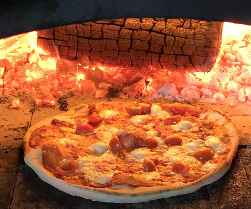 imagen de pizza hecha en horno de leña